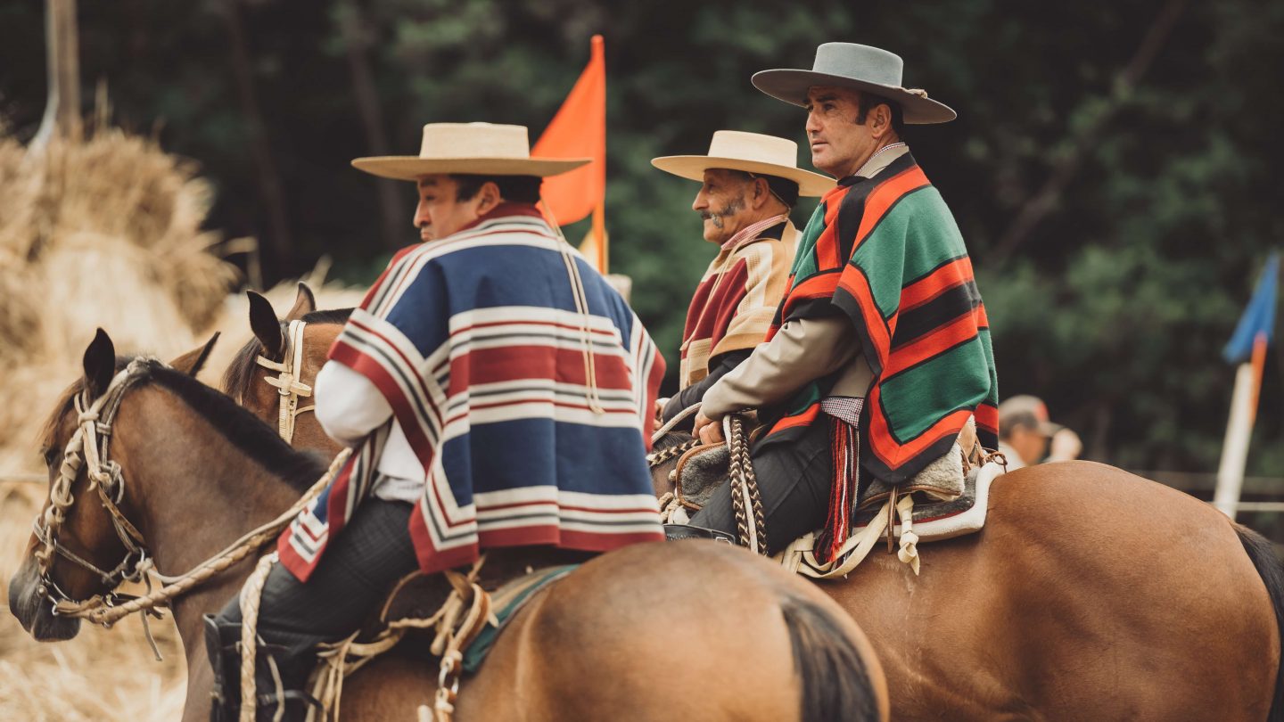 Chilean Huasos in traditional dress, sitting on horses