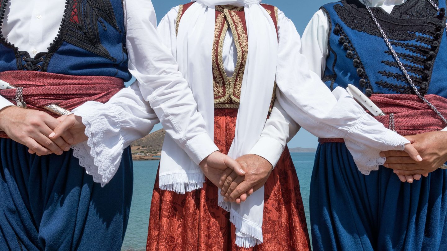 Cretan dancers holding hands in traditional clothes